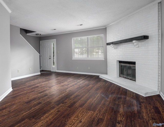 unfurnished living room featuring hardwood / wood-style flooring, crown molding, a brick fireplace, and a textured ceiling