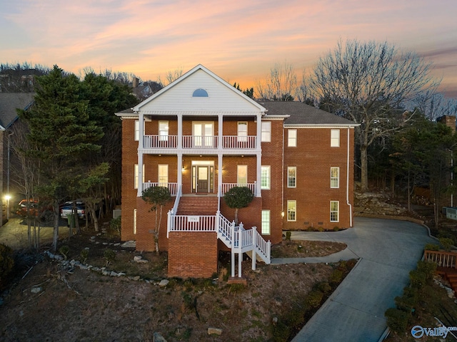 greek revival house with a balcony and covered porch