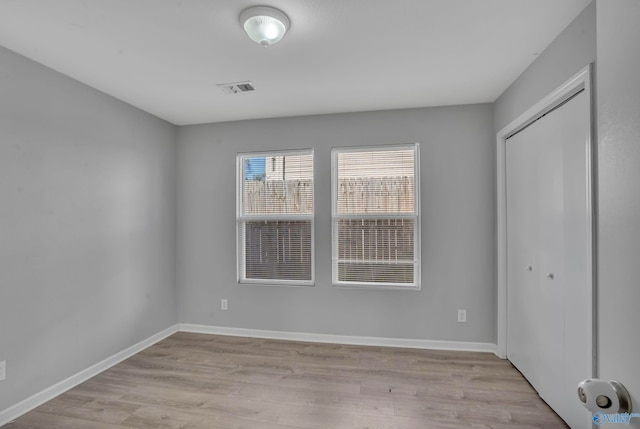 unfurnished bedroom with a closet and light wood-type flooring