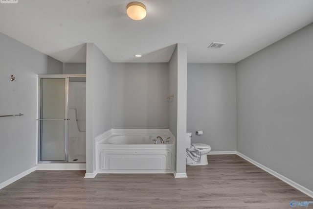 bathroom featuring toilet, hardwood / wood-style flooring, and plus walk in shower