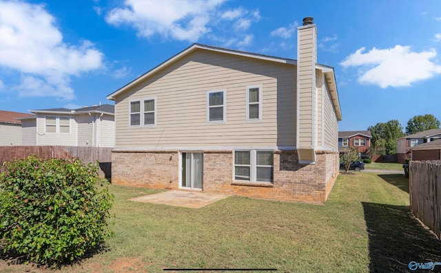 rear view of property featuring a yard and a patio