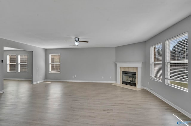 unfurnished living room featuring light hardwood / wood-style floors, a fireplace, and ceiling fan