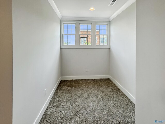 carpeted spare room featuring crown molding