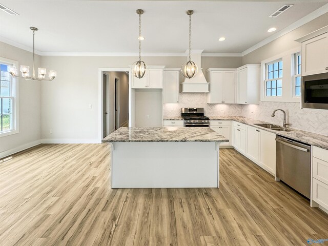 kitchen featuring tasteful backsplash, white cabinets, light hardwood / wood-style floors, appliances with stainless steel finishes, and sink