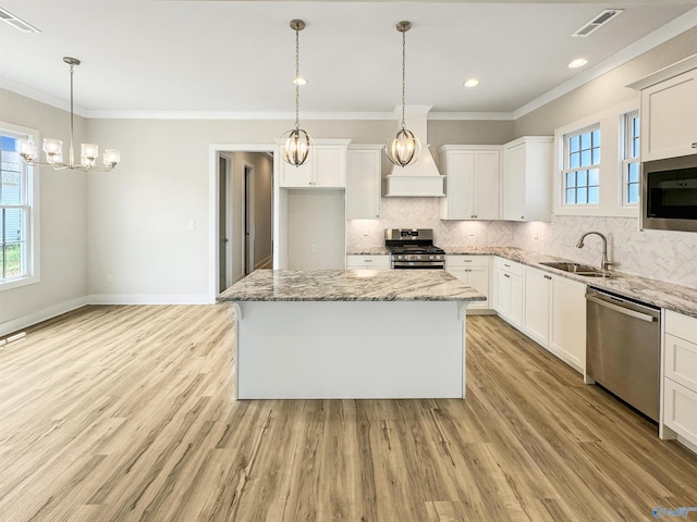 kitchen featuring a kitchen island, appliances with stainless steel finishes, sink, and white cabinets