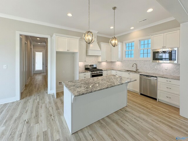 kitchen featuring tasteful backsplash, stainless steel appliances, sink, light hardwood / wood-style floors, and white cabinetry