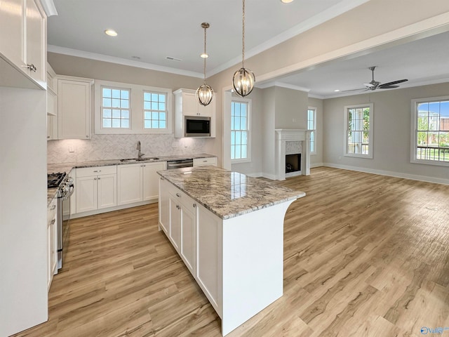 kitchen featuring a center island, light wood-type flooring, tasteful backsplash, and stainless steel appliances