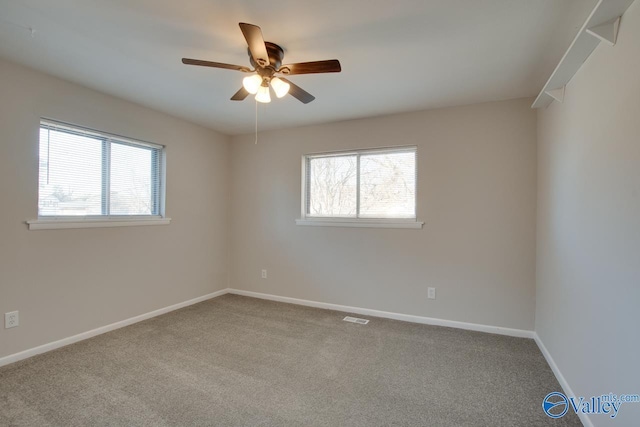 carpeted spare room featuring ceiling fan