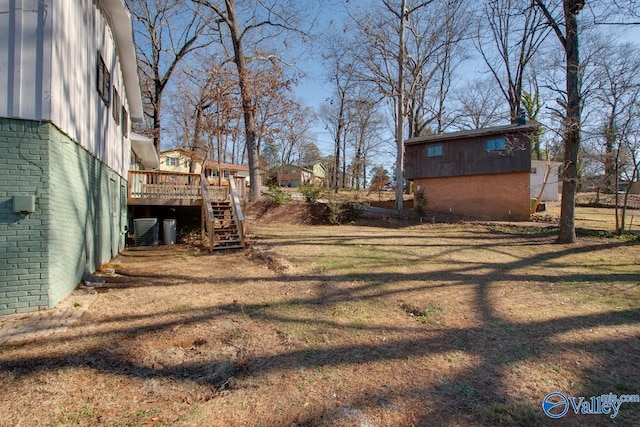 view of yard featuring cooling unit and a deck