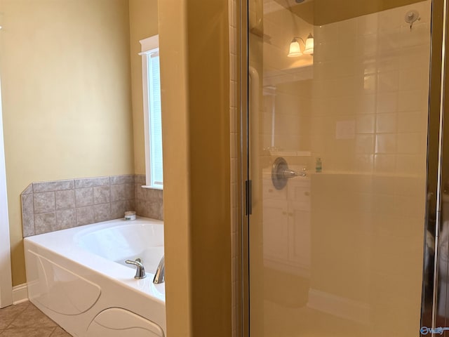 bathroom featuring a shower stall, tile patterned floors, and a bath