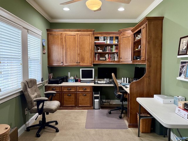 office with crown molding, built in study area, light carpet, and a ceiling fan