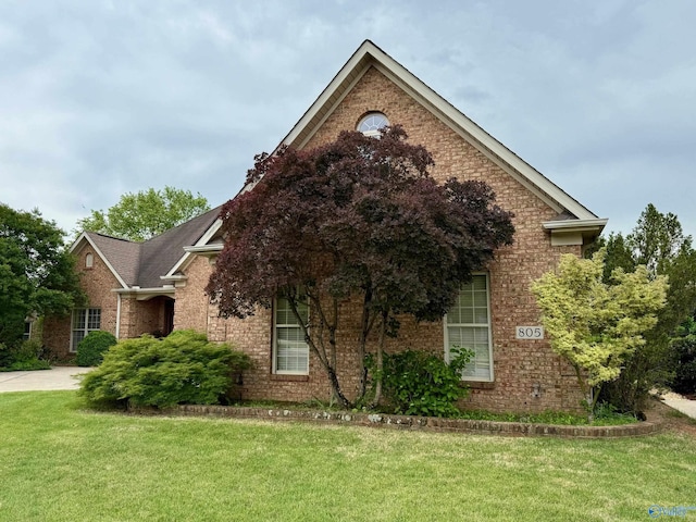 view of home's exterior featuring a yard and brick siding