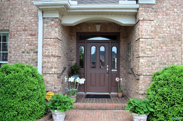 view of exterior entry featuring brick siding