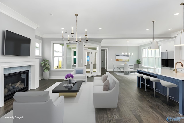 living room with ornamental molding, dark hardwood / wood-style floors, sink, and a chandelier