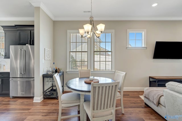 dining area with visible vents, a notable chandelier, ornamental molding, baseboards, and dark wood-style flooring