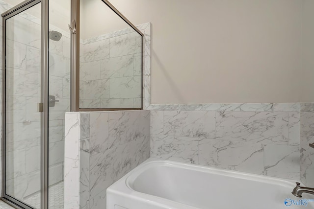 bathroom featuring a shower stall and a garden tub