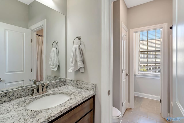 full bathroom featuring baseboards, toilet, vanity, and tile patterned flooring