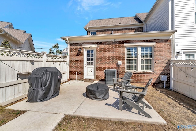 view of patio featuring central air condition unit, a fire pit, a fenced backyard, and grilling area