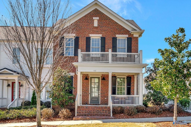 view of front of home featuring a porch, a balcony, and brick siding