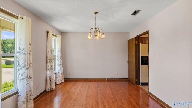 2302 Auburn Dr, Decatur, AL 35603 - unfurnished room featuring light wood-style flooring, a chandelier, healthy amount of natural light, and baseboards
