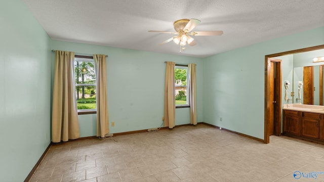 2302 Auburn Dr, Decatur, AL 35603 - unfurnished room with plenty of natural light, a ceiling fan, baseboards, a textured ceiling, and a sink