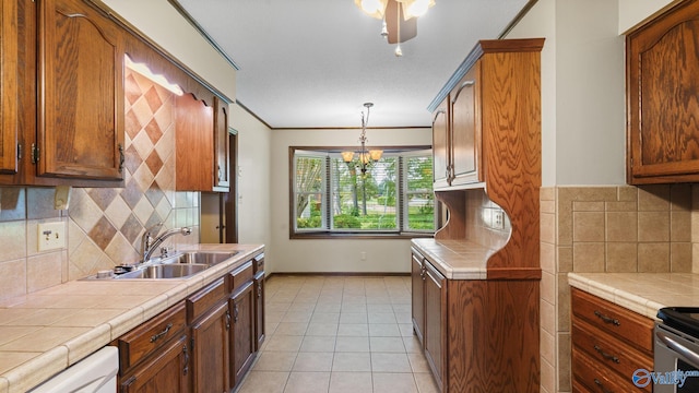 2302 Auburn Dr, Decatur, AL 35603 - kitchen with a sink, tile counters, dishwasher, a chandelier, and baseboards