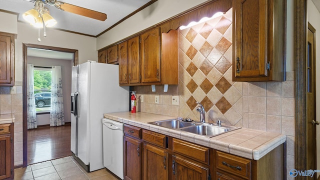 2302 Auburn Dr, Decatur, AL 35603 - kitchen with white appliances, a sink, ceiling fan, light tile patterned floors, and decorative backsplash