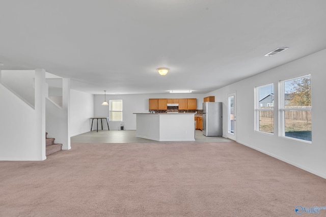 unfurnished living room featuring light carpet