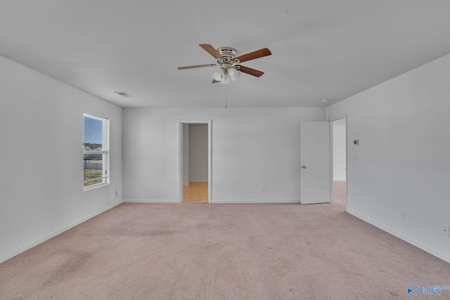 empty room with ceiling fan and light carpet