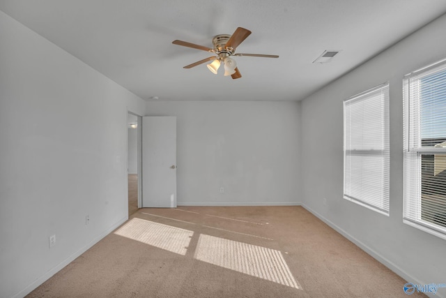 carpeted spare room featuring ceiling fan