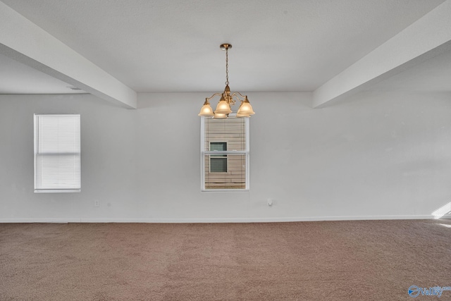 spare room featuring carpet, beam ceiling, and an inviting chandelier