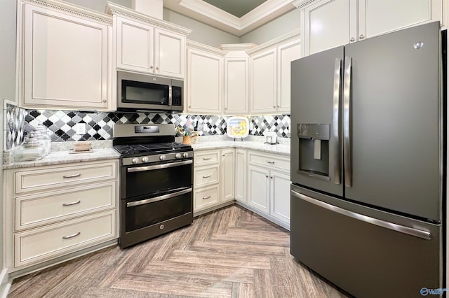kitchen with ornamental molding, backsplash, light stone counters, and stainless steel appliances