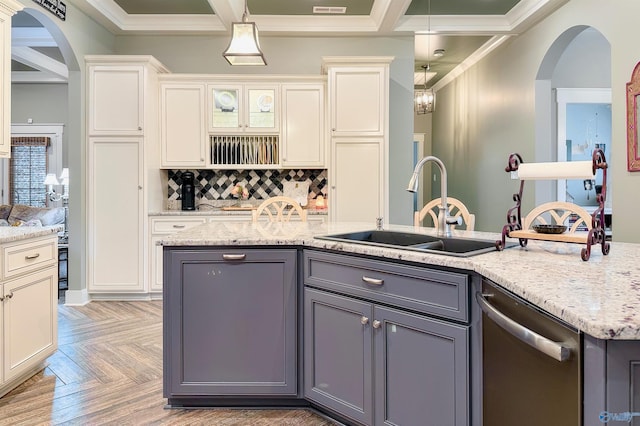 kitchen featuring stainless steel dishwasher, crown molding, a sink, arched walkways, and gray cabinetry