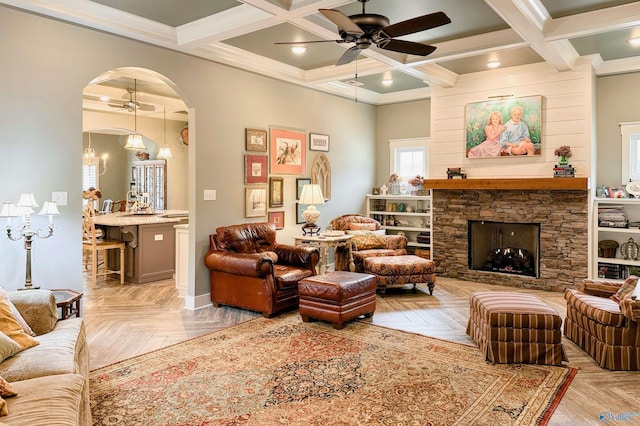 living room featuring arched walkways, beamed ceiling, ceiling fan, and coffered ceiling