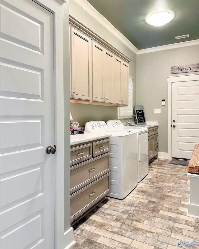 laundry area with visible vents, ornamental molding, brick floor, washing machine and clothes dryer, and cabinet space