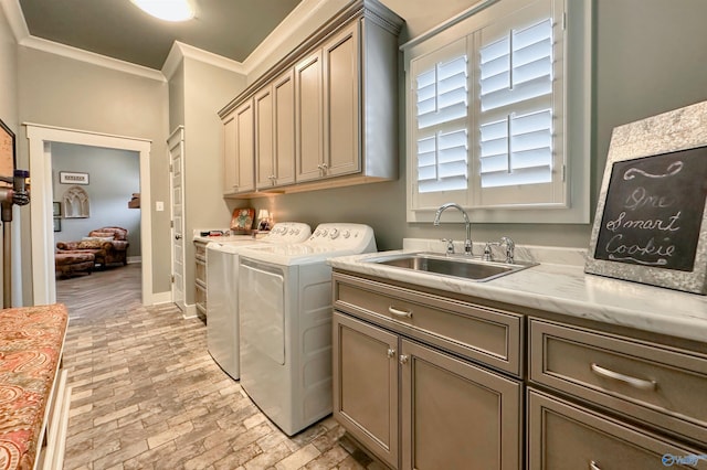 clothes washing area with a sink, cabinet space, crown molding, brick floor, and washer and dryer