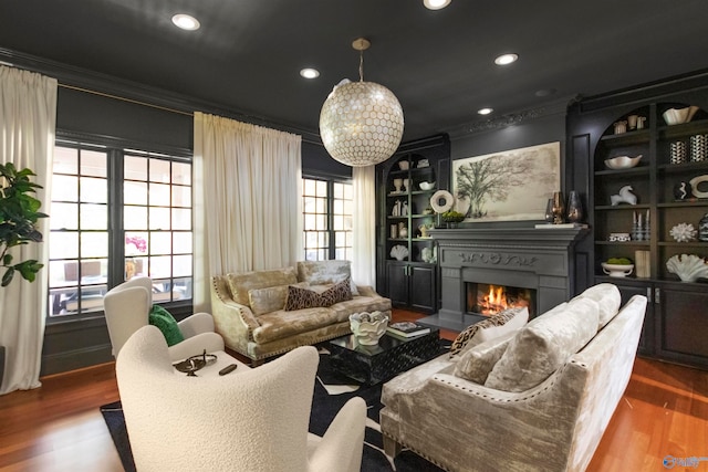 interior space featuring ornamental molding, built in shelves, and hardwood / wood-style floors