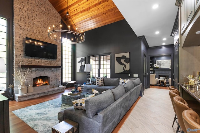 living room featuring a stone fireplace, light hardwood / wood-style flooring, high vaulted ceiling, and wooden ceiling