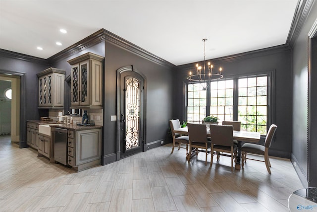 dining space featuring light hardwood / wood-style floors, ornamental molding, and a chandelier