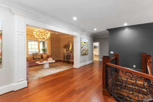 hall with ornamental molding, a chandelier, and hardwood / wood-style flooring