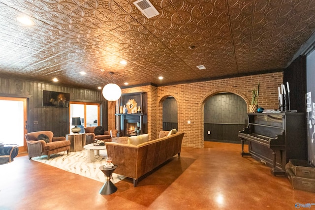 living room with concrete flooring and brick wall