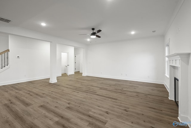 unfurnished living room featuring ornamental molding, dark wood-type flooring, and ceiling fan