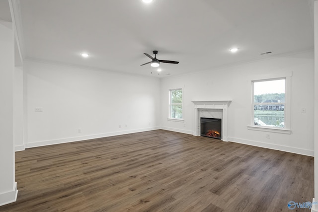 unfurnished living room with a premium fireplace, dark hardwood / wood-style floors, ceiling fan, and crown molding