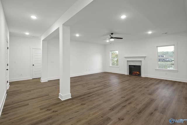 unfurnished living room with dark wood-type flooring, ceiling fan, and a high end fireplace