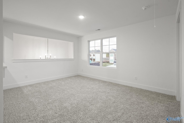 empty room featuring a chandelier and carpet