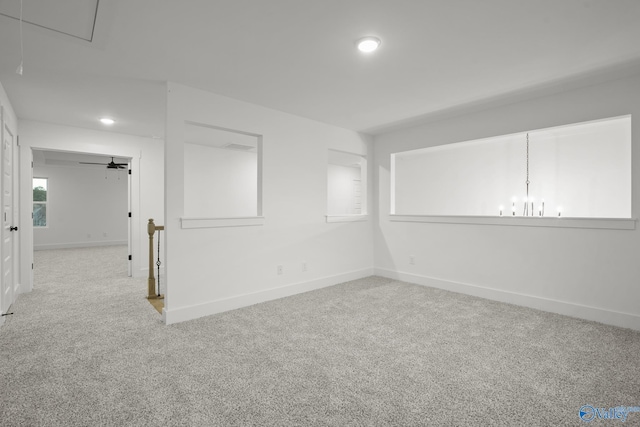 carpeted spare room featuring an inviting chandelier