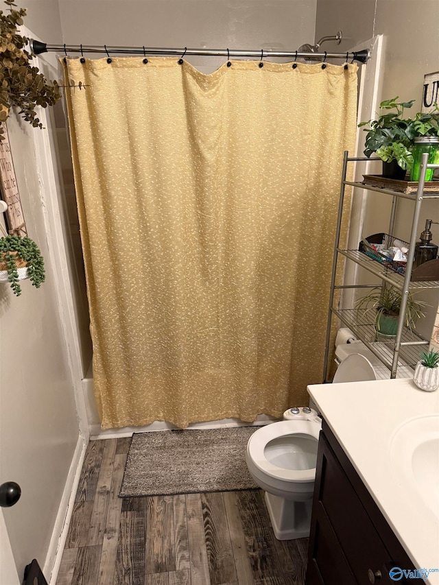 full bathroom featuring toilet, shower / bathtub combination with curtain, vanity, and wood-type flooring