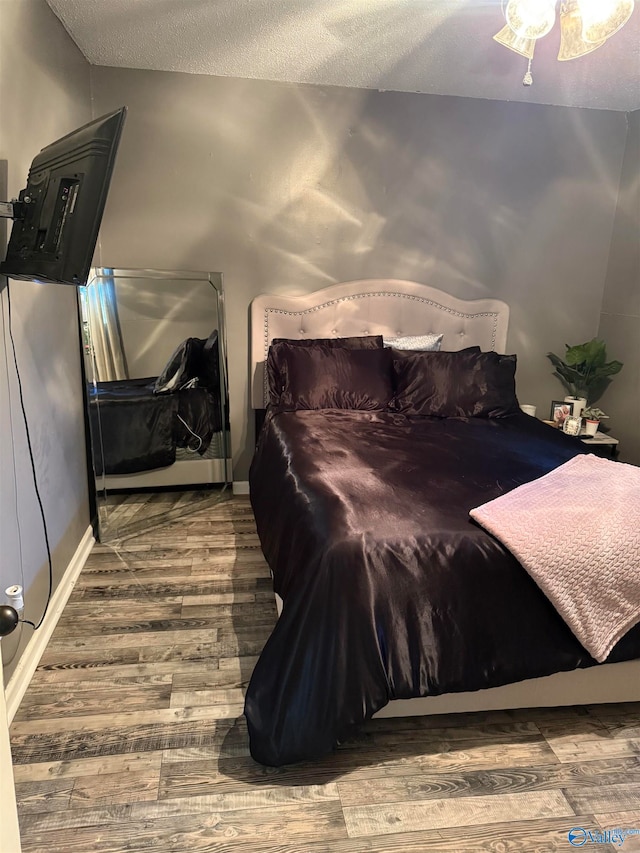 bedroom featuring a textured ceiling, hardwood / wood-style flooring, and ceiling fan