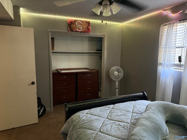 bedroom with a textured ceiling, carpet floors, a closet, and ceiling fan