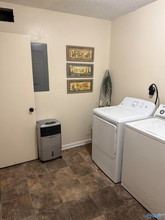 laundry area featuring electric panel, washing machine and clothes dryer, and a textured ceiling